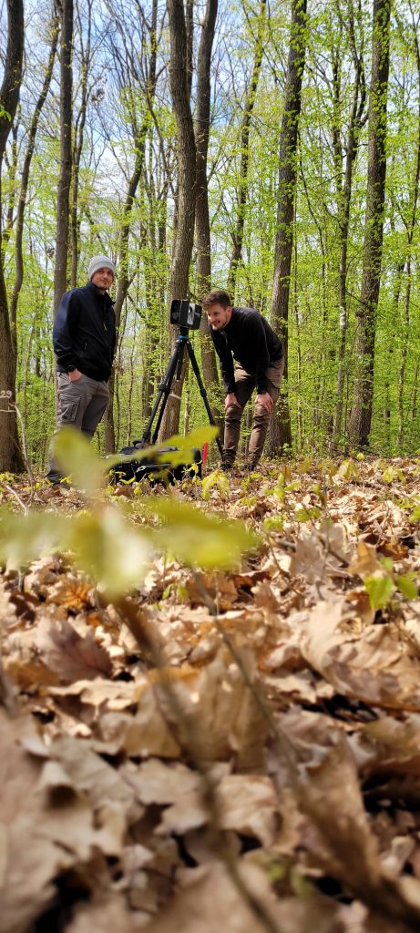 Two experts working with Terrestrial Laser Scanning (TLS) in a forest